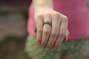 Hand mit aus Gras geflochtenem Ring am Finger